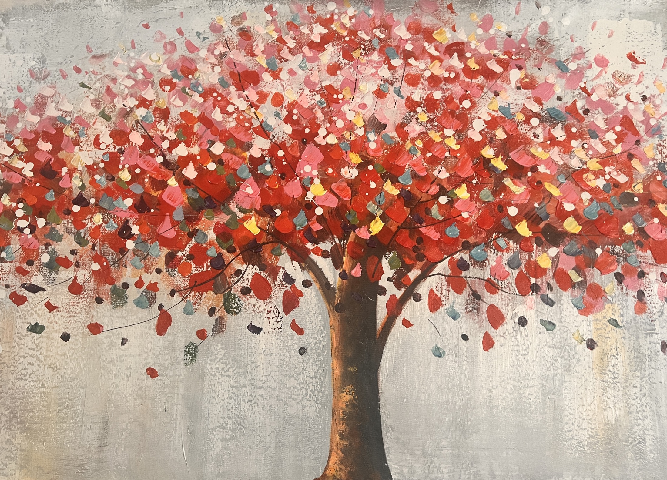 Blossoming tree with a broad crown of red, pink and gold petals